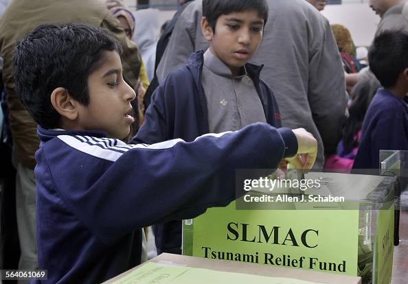 Hash Simjee Huzaifah Simjee left, and brother Zayd Simjee right, place money in ...