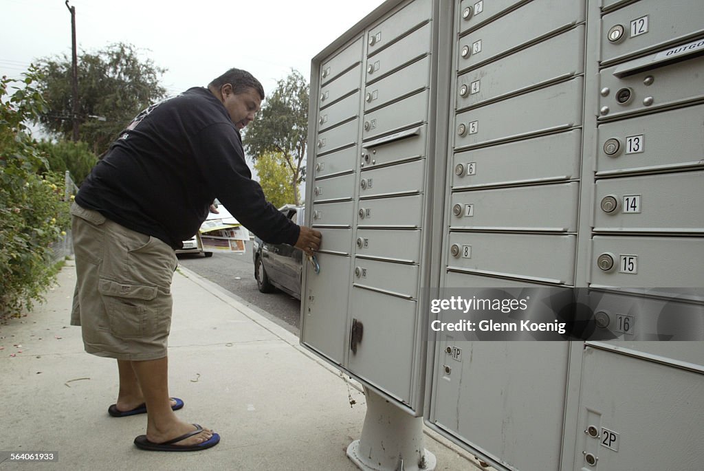 Carlton Ave. resident Nash Gonzales picks up his mail at the centralized cluster mailboxes at he co