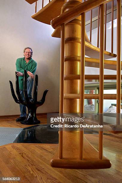 Thom Beers posing with "Hand" chair by the staircase of the twostory den of his home. The chair is from the mid '60s by the Mexican designer Pedro...