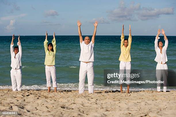 five people exercising on the beach - rolled up pants stock pictures, royalty-free photos & images