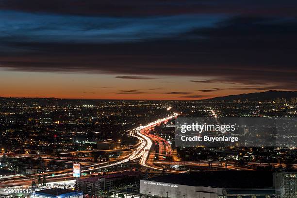 Dusk skyline view of Los Angeles, California, looking west over the Interstate 10 freeway toward the setting sun