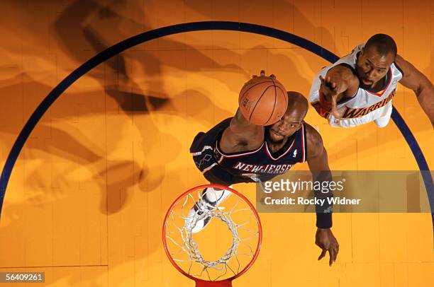 Marc Jackson of the New Jersey Nets takes the ball to the basket past Derek Fisher of the Golden State Warriors during a game at The Arena in Oakland...