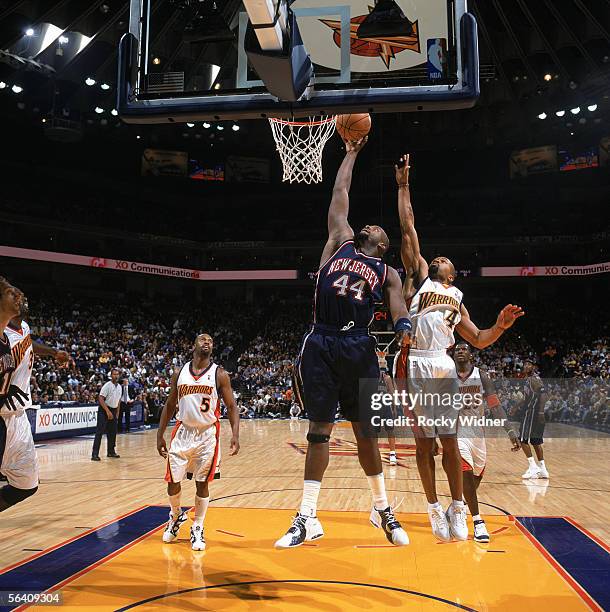 Marc Jackson of the New Jersey Nets takes the ball to the basket past Derek Fisher of the Golden State Warriors during a game at The Arena in Oakland...