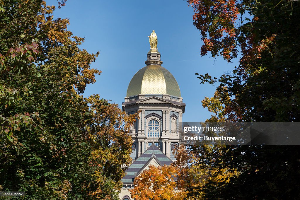 The Main Building gold dome topped by a golden statue of St. Mary at the University of Notre Dame, a