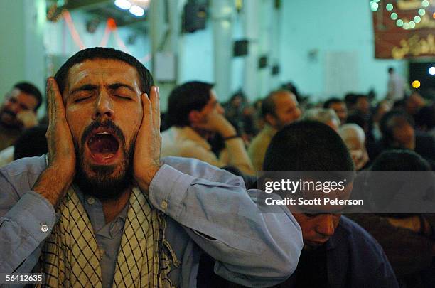 Man with a scarf of the hardline Basiji militia holds his head at the Jamkaran Mosque December 6, 2005 in Jamkaran, Iran. Some Iranian Shiites...