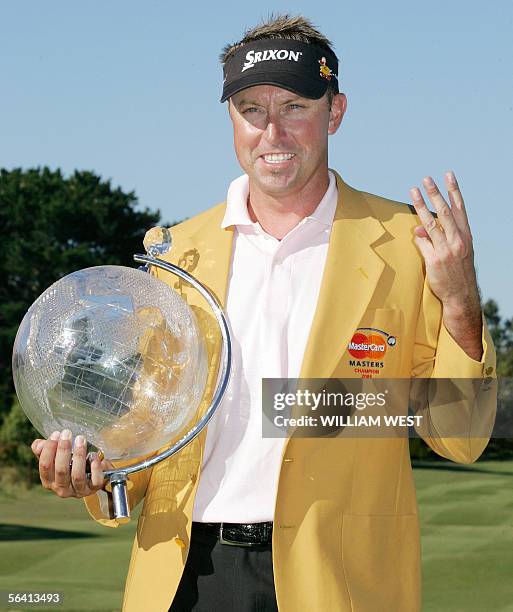 Australian Robert Allenby holds up the trophy and three fingers after winning the Australian Masters played at the Huntingdale course in Melbourne,...