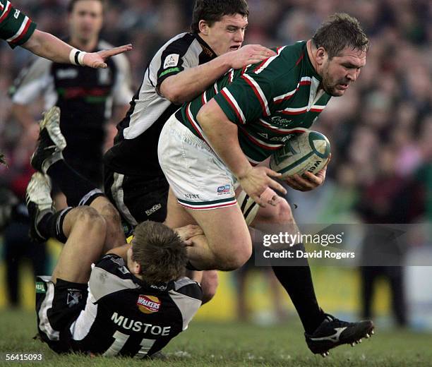 Darren Morris, the Leicester prop is tackled by Richard Mustoe and Ian Evans of the Ospreys during the Heineken Cup match between Leicester Tigers...
