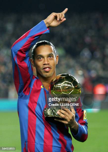 Barcelona's Brazilian Ronaldinho shows his 'Ballon d'or' trophy before the Spanish League football match against Sevilla CF at the Camp Nou stadium...