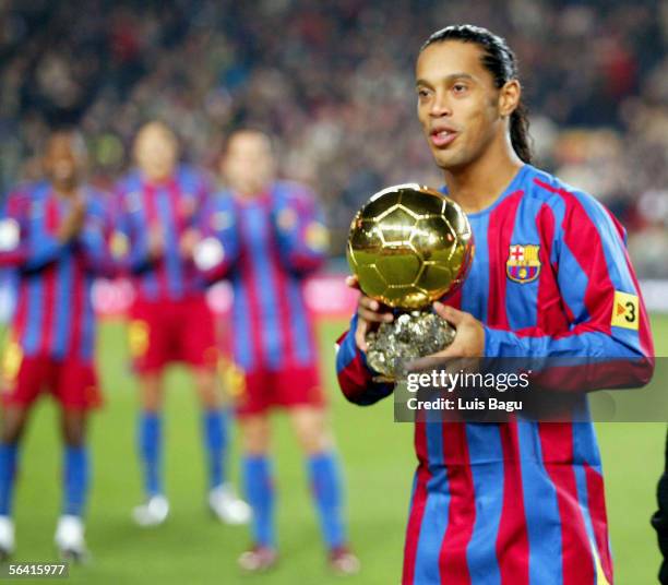 Ronaldinho of Barcelona is applauded by his team-mates as he holds the Ballon D'Or award for European Footballer of the Year on the pitch before the...