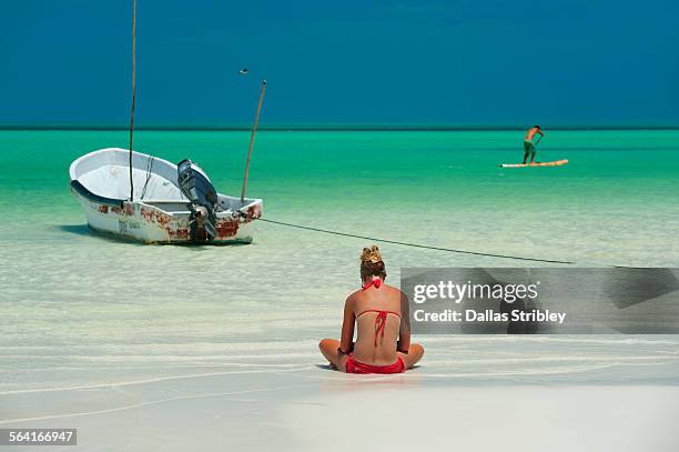 woman reading on the sea shore, holbox, mexico - isla holbox stock-fotos und bilder