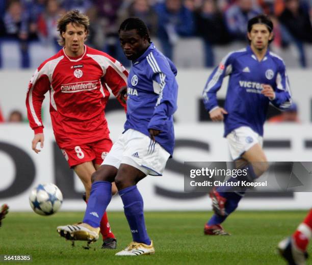 Fabian Gerber of Mainz tackles Gerald Asamoah of Schalke during the Bundesliga match between Schalke 04 and FSV Mainz 05 at the Veltins Arena on...