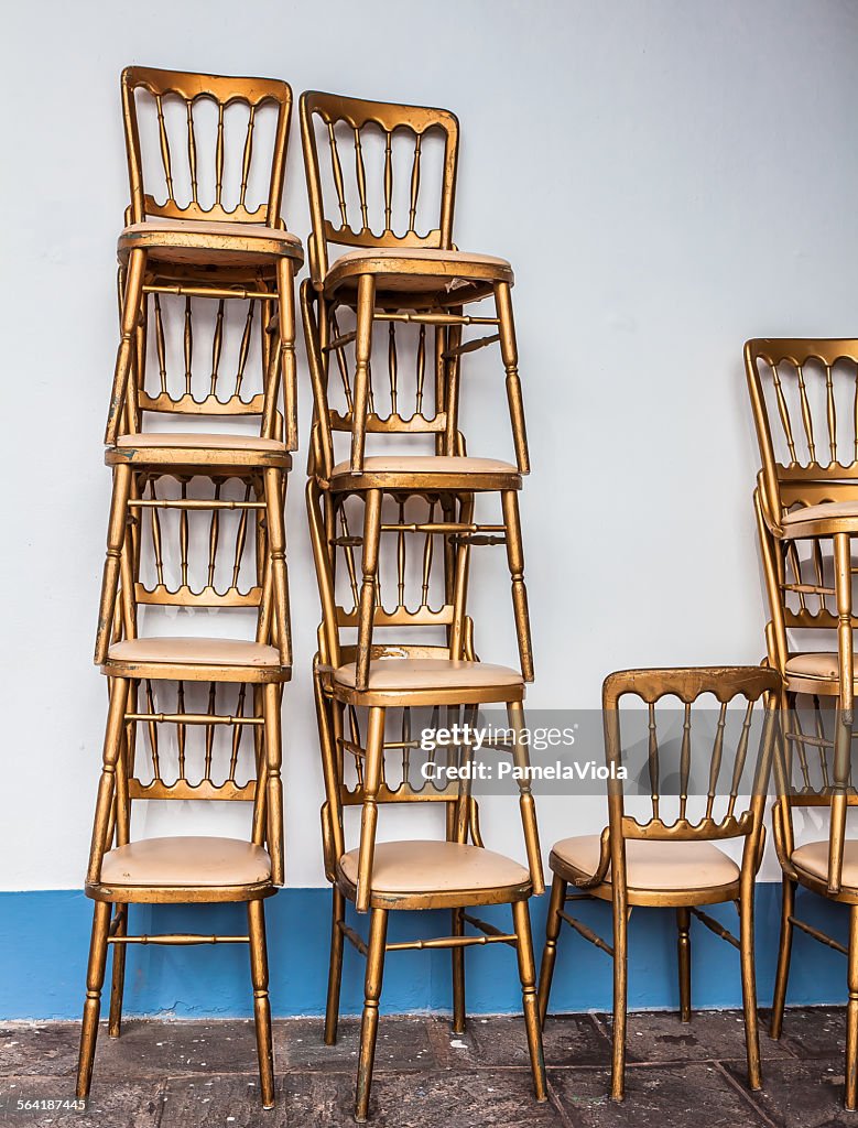 Stacks of gold ballroom chairs