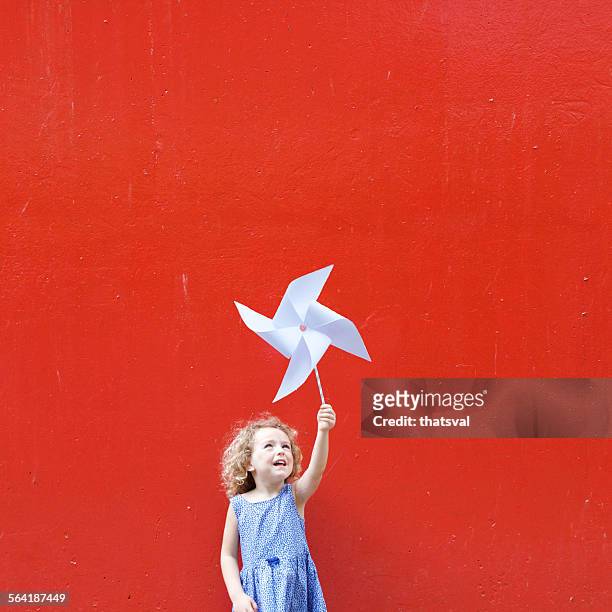 smiling girl holding a pinwheel in the air making a hong kong flag - asian flags stock pictures, royalty-free photos & images