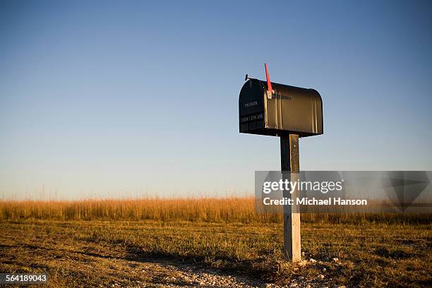 a mailbox stands alone in a kansas corn field as the sun sets beyond the horizon. - brevlåda bildbanksfoton och bilder