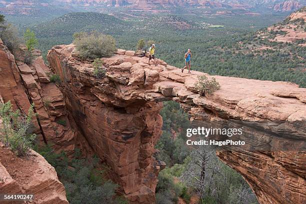 hikers on the devils bridge in red rock-secret mountain wilderness area outside sedona, arizona may 2011. - sedona stockfoto's en -beelden