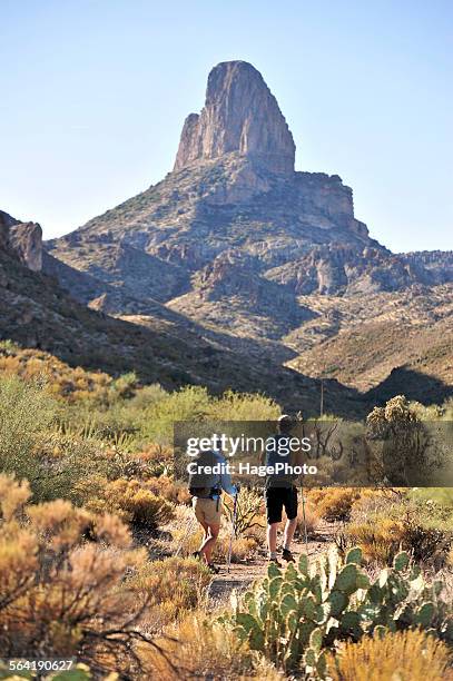 man and woman backpackers hike on the popular peralta trail in the superstition wilderness area, tonto national forest near phoenix, arizona november 2011. - gebirge superstition mountains stock-fotos und bilder