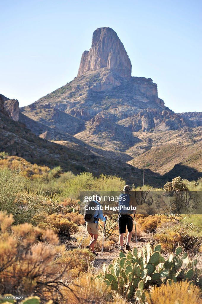 Man and woman backpackers hike on the popular Peralta Trail in the Superstition Wilderness Area, Tonto National Forest near Phoenix, Arizona November 2011.