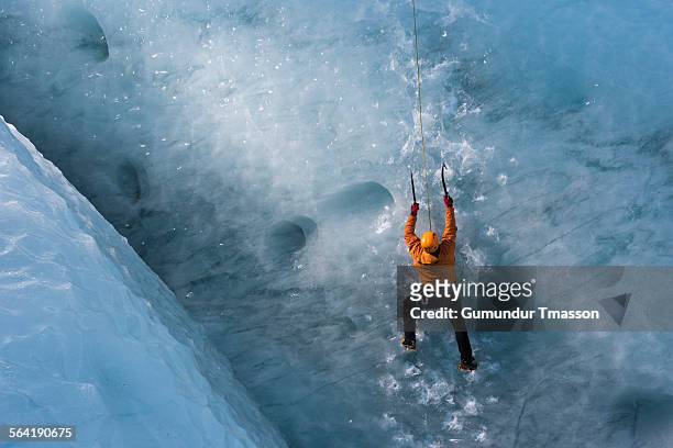 man climbing vertical glacier ice wall - ice climbing stockfoto's en -beelden