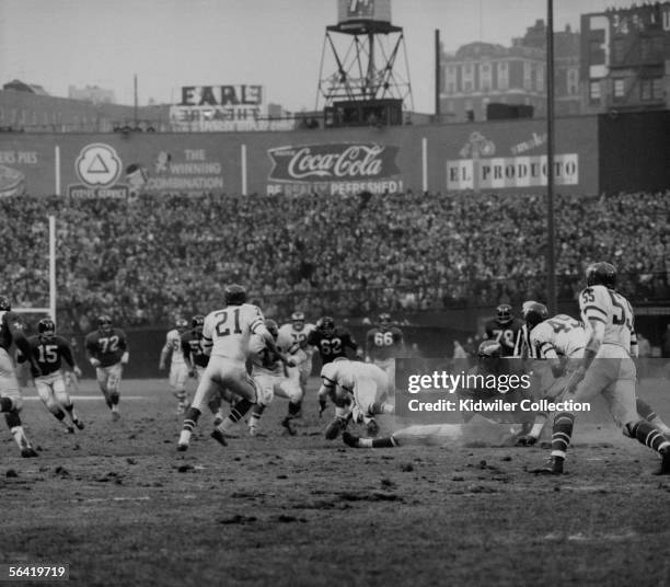 Frank Gifford, of the New York Giants, lays hurt on the field after being hit by Chuck Bednarik, of the Philadelphia Eagles, to stop the last chance...