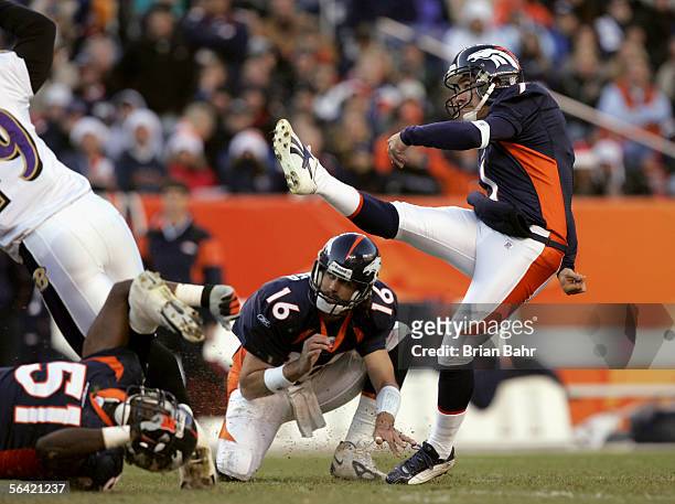 Quarterback Jake Plummer of the Denver Broncos holds the ball so kicker Jason Elam can attempt to score against the Baltimore Ravens during the game...