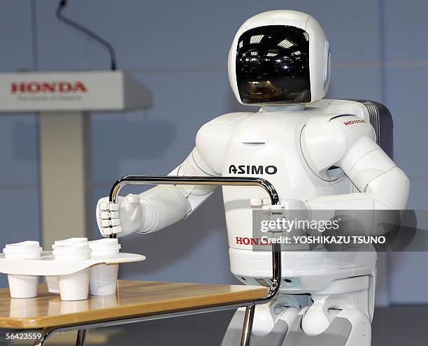 Japanese auto giant Honda Motor's new humanoid robot Asimo, which enables to run at a speed of 6kph and to run in a circular pattern, pushes a cart...
