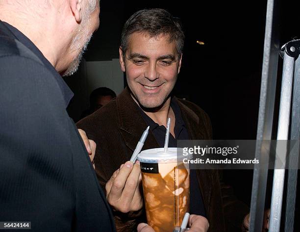 Actors Frank Langella and George Clooney sign a movie poster at the Variety Screening Series of "Good Night And Good Luck" at the Arclight Theaters...