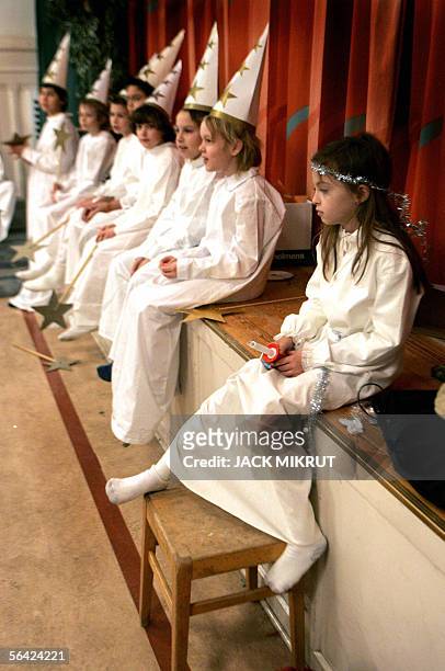 Sarah Cassantini sits in the foreground, dressed as a maiden of Lucia Queen of Lights while boys dressed as Saint Staffan sit in the background at...