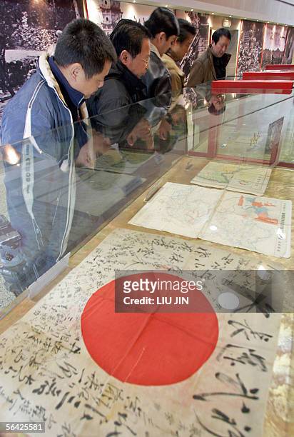 Visitors view a Japanese war-time army flag displayed at the Anti-Japanese War Museum in Dayi county in China's southwestern province of Sichuan, 13...