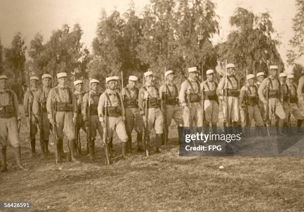 Members of the French Foreign Legion stationed in Africa stand at attention on the parade ground, early 1900s.