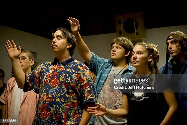 Youth worship with hands raised in praise at a campmeeting service for junior high and high school students during Eaton Rapids Campmeeting on July...