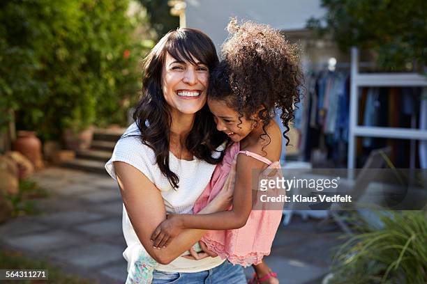 mother carrying daughter & both laughing - women 35 foto e immagini stock