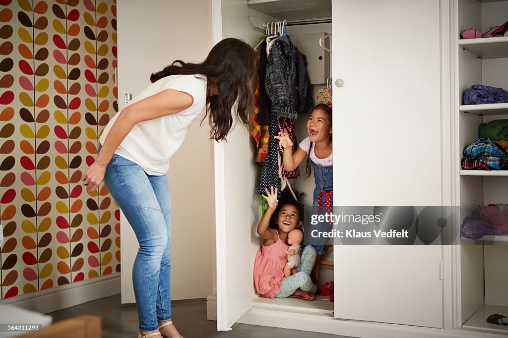 Mother & daughter playing Hide & Seek in closet