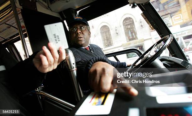 New York City bus driver David Smith points out how to use the fare system to a passenger December 14, 2005 in New York City. New York City Transit...