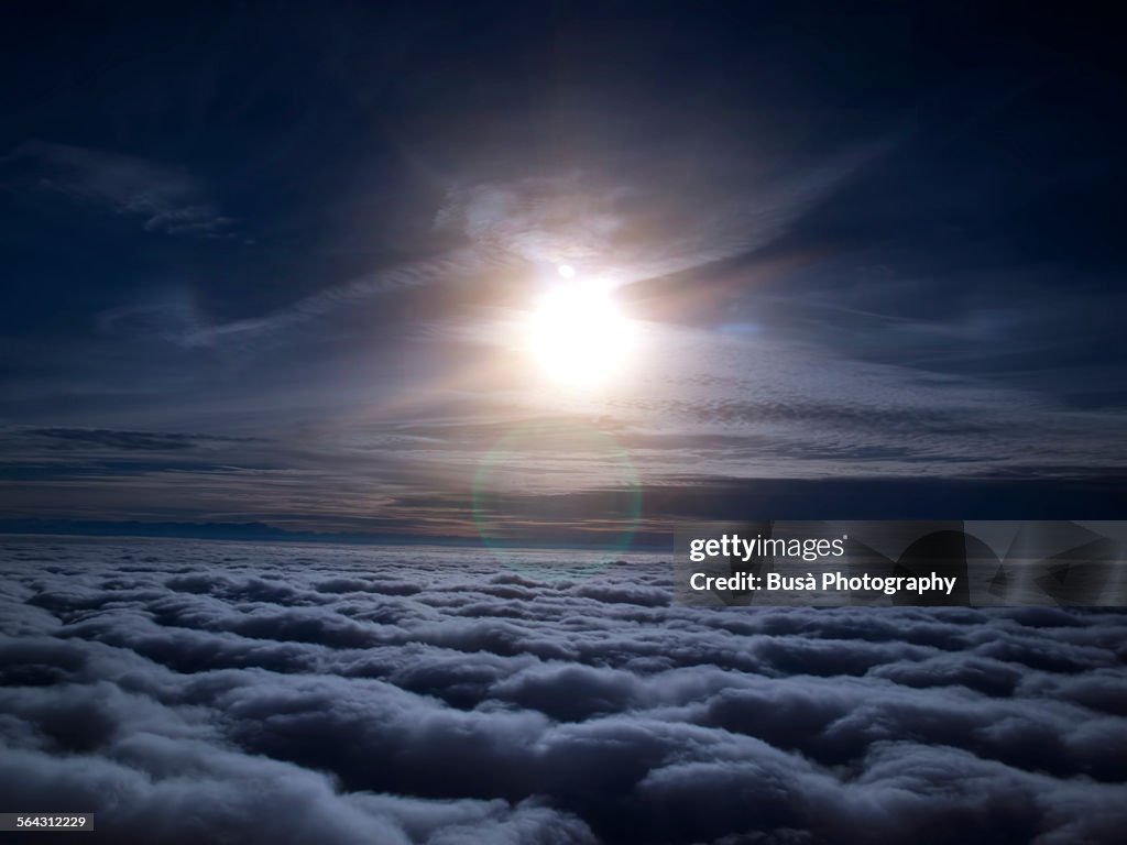Night view of moon over clouds from aircraft
