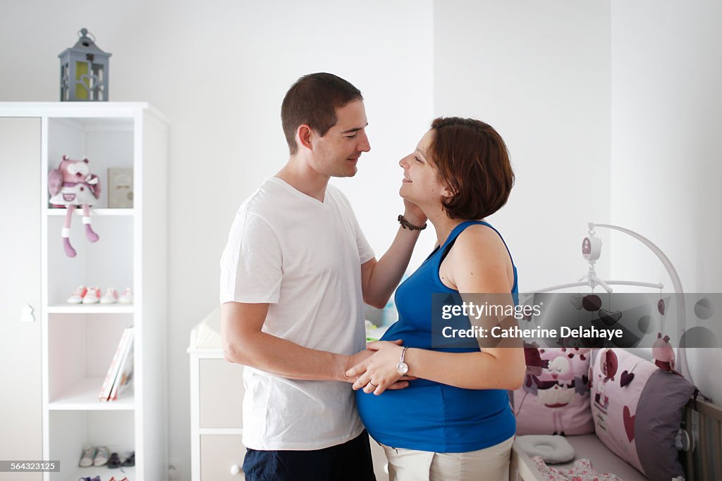 A pregnant woman posing with her husband