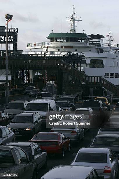 Cars exit a Washington State Ferry running between Seattle and Bainbridge Island, as others wait to board December 14, 2005 at Seattle Pier 52 in...