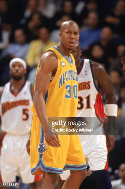 David West of the New Orleans/Oklahoma City Hornets frowns as he walks on the court during a game against the Golden State Warriors at The Arena in...