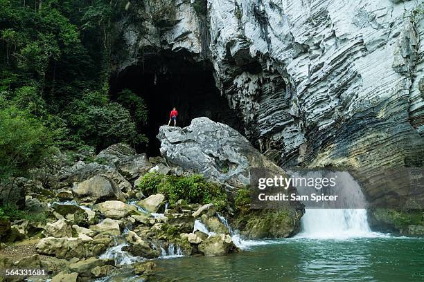 man standing at cave entrance - phong nha kẻ bàng national park fotografías e imágenes de stock