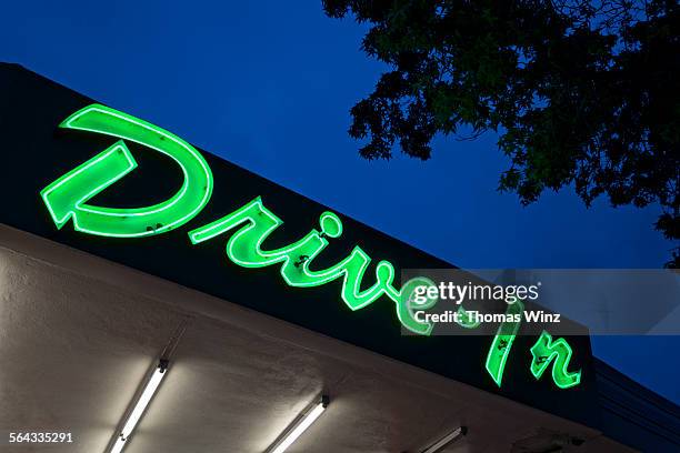 neon drive in sign at dusk - drive in movie theater stock pictures, royalty-free photos & images