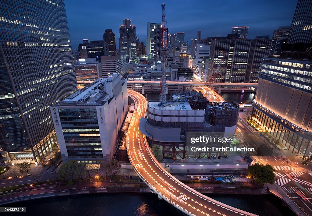 Osaka skyline with curved elevated highway at dusk
