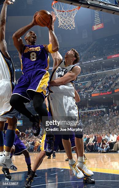 Kobe Bryant of the Los Angeles Lakers shoots a layup over Mike Miller of the Memphis Grizzlies on December 14, 2005 at FedExForum in Memphis,...