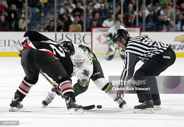 Niko Kapanen of the Dallas Stars faces off against Adam Mair of the Buffalo Sabres as linesman Steve Barton drops the puck on December 14, 2005 at...