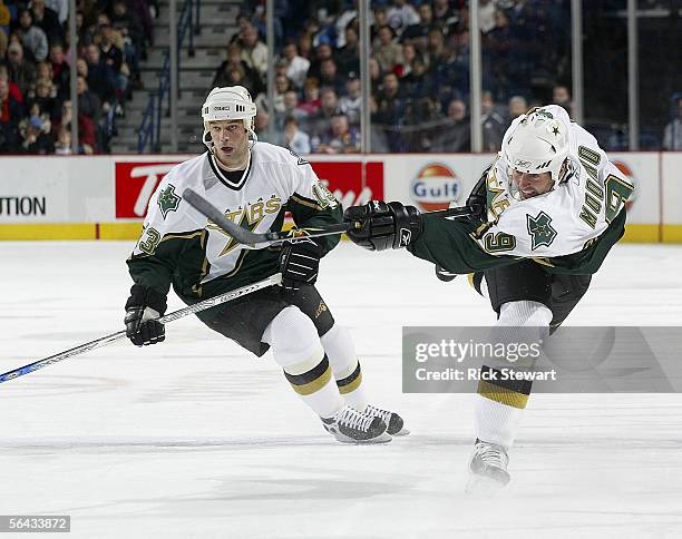 Mike Modano of the Dallas Stars shoots with teammate Bill Guerin behind him against the Buffalo Sabres on December 14, 2005 at HSBC Arena in Buffalo,...