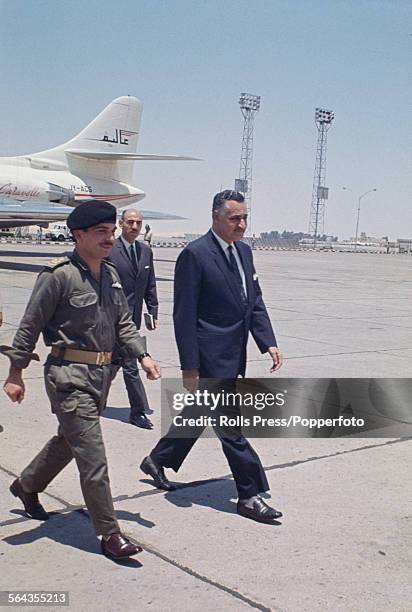 King Hussein of Jordan on left, walks with President of Egypt, Gamel Abdel Nasser along the apron of an airport in Cairo, Egypt prior to the start of...