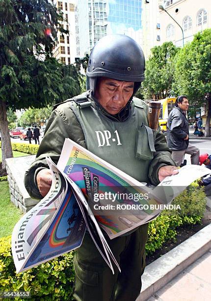 An antiriot policeman reads a leaflet about presidential national elections of December 18, 2005 in downtown La Paz, 15 December 2005. Some 3.5...