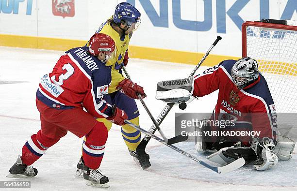Moscow, RUSSIAN FEDERATION: Yevgeni Varlamov of Russia tries to stop Dragan Umicevic of Sweden as he attacks Russian goalkeeper Maxim Sokolov at the...