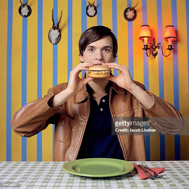 young man eating burger, portrait - plate eating table imagens e fotografias de stock