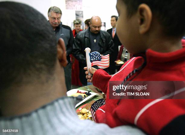 Washington, UNITED STATES: A boy holds a cookie in the shape of a US flag during a naturalization ceremony for new US citizens 15 December, 2005 in...