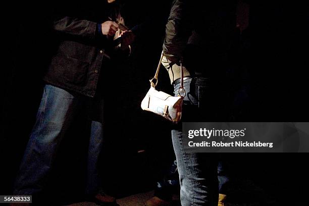 Suffolk County Anti-Gang Policemen check the identity documents of a local woman suspected of being a prostitute on November 11, 2005 in Brentwood,...