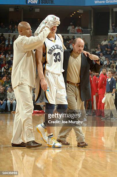 Mike Miller of the Memphis Grizzlies leaves the court after suffering a concussion and a laceration above his left eye during a scramble for the ball...